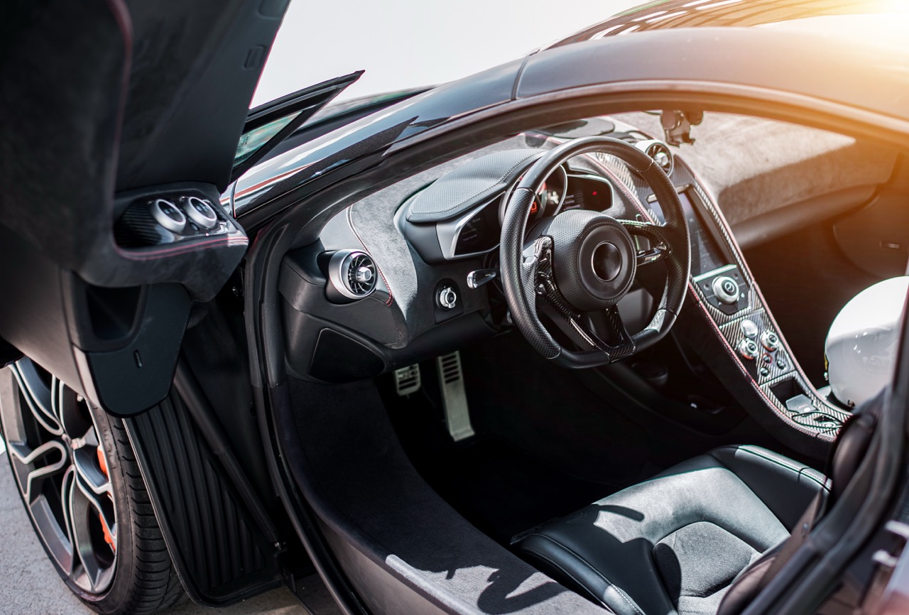 Black sport car front side salon view, black wheel with metallic silver color, direction, door open. image